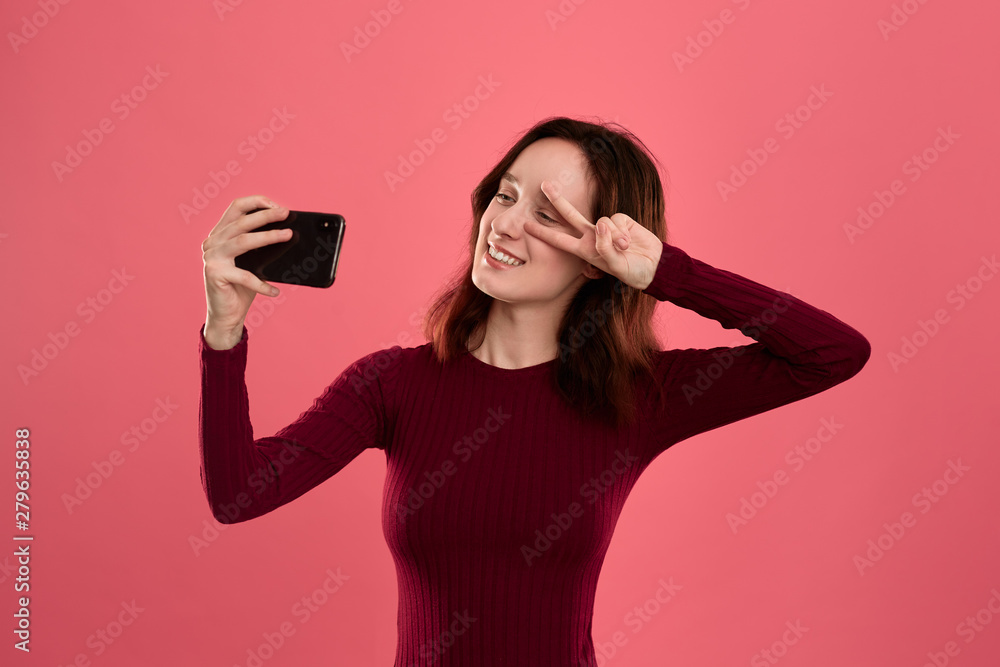 Photo of a pretty young brunette woman making selfie with a mobile phone