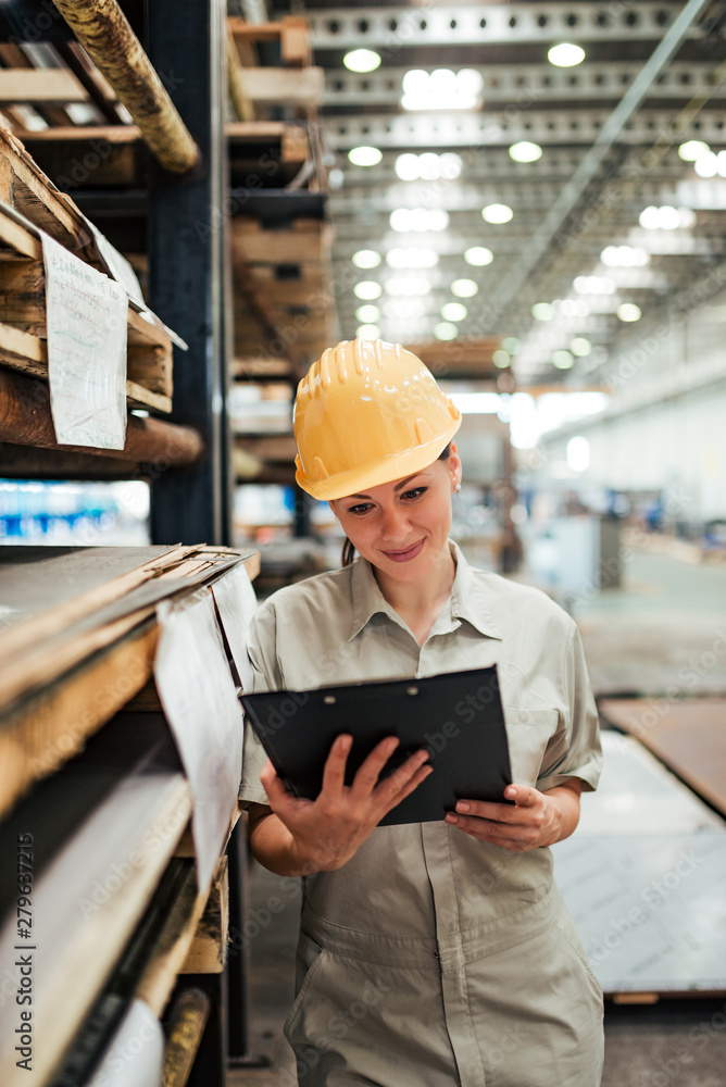 Positive female factory worker with clipboard at warehouse. Positive female factory worker with clipboard at warehouse.