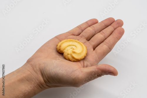 Hand holding the homemade cookie isolated on white