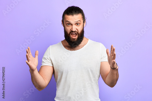 angry nervous frustrated man with hand raised open mouth shouting at somebody, isolated on blue background. Negative emotion, facial expression feelings.close up portrait. feeling