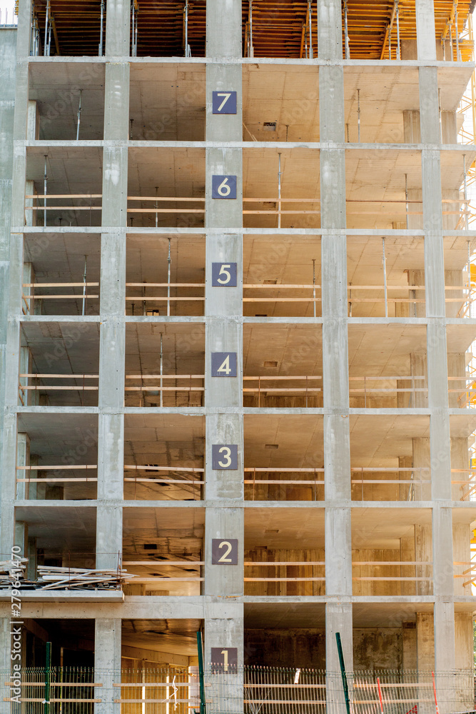 Modern building under construction detail, concrete frame, indow openings and scaffolding Modern building under construction detail, concrete frame, indow openings and scaffolding