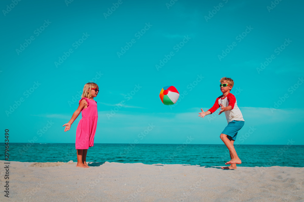 kids play with ball on beach, boy and girl have fun at sea kids play with ball on beach, boy and girl have fun at sea