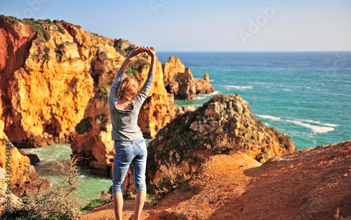 Young woman at sea cliffs, Lagos, Portugal