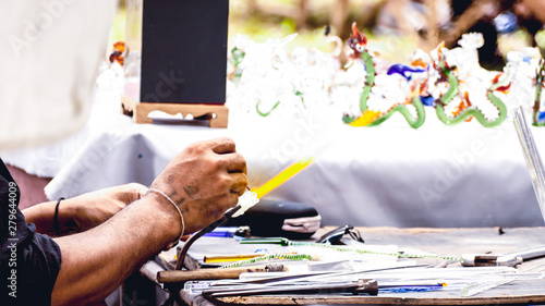 Slika na platnu In the hand, holding the steel bar and the glass the blown glass