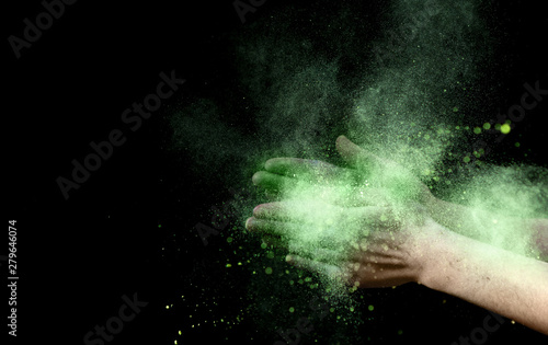 Yellow explosion of holi color powder inside clapping hands
