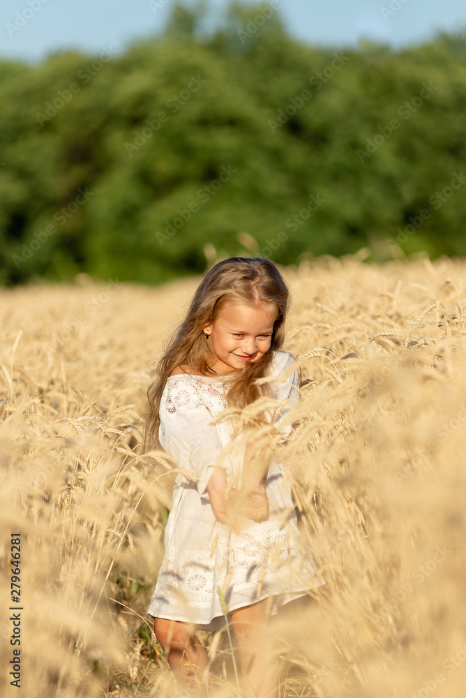 little blonde girl stands in a wheat field in summer and smiles little blonde girl stands in a wheat field in summer and smiles