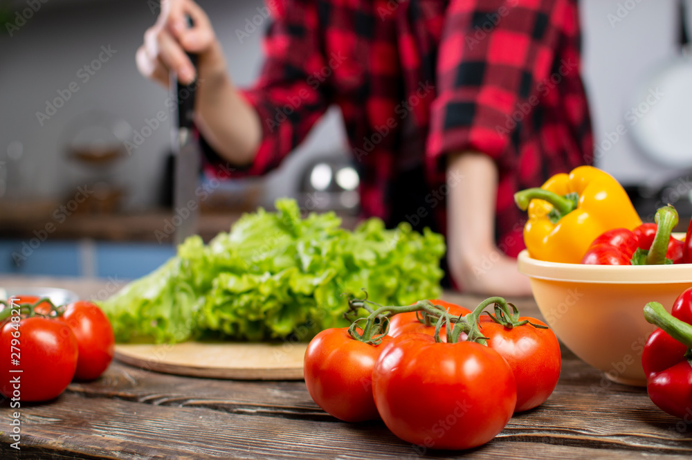 Tomatoes, peppers and greens, lie on a wooden table, ingredients for making salad, close-up of healthy food Tomatoes, peppers and greens, lie on a wooden table, ingredients for making salad, close-up of healthy food