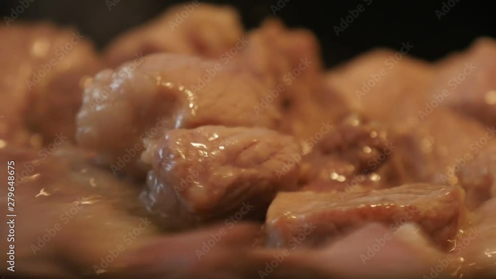 young woman mixing frying pork in the pan with a lot of oil, Close up young woman mixing frying pork in the pan with a lot of oil, Close up