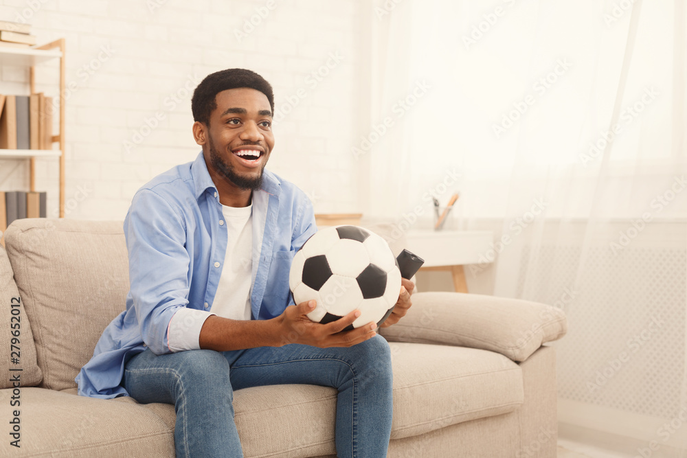 Excited black guy watching sports on tv at home Excited black guy watching sports on tv at home