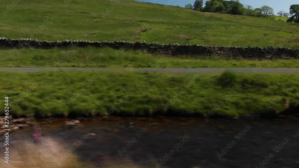 A Dolly style shot (actually shot with a drone) of a country wall and stream. The shot was taken at Barbon Beck Valley, Carnforth. Travelling left to right. A Dolly style shot (actually shot with a drone) of a country wall and stream. The shot was taken at Barbon Beck Valley, Carnforth. Travelling left to right.