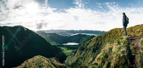 Young Man Tourist standing overlooking at Picturesque view of the Lake of Sete Cidades Seven Cities Lake , a volcanic crater lake on Sao Miguel island, Azores, Portugal. View from Vista do Rei