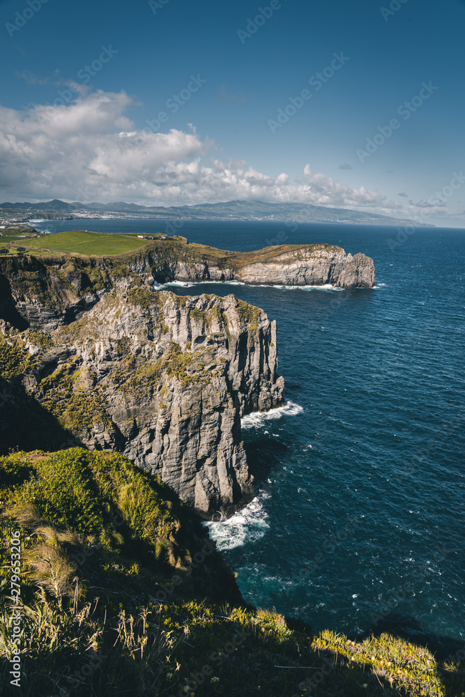 Lookout from Ponta do Cintrao at cliffs and coastline in sunny weather with beautiful cloudy blue sky, Sao Miguel Island, Azores