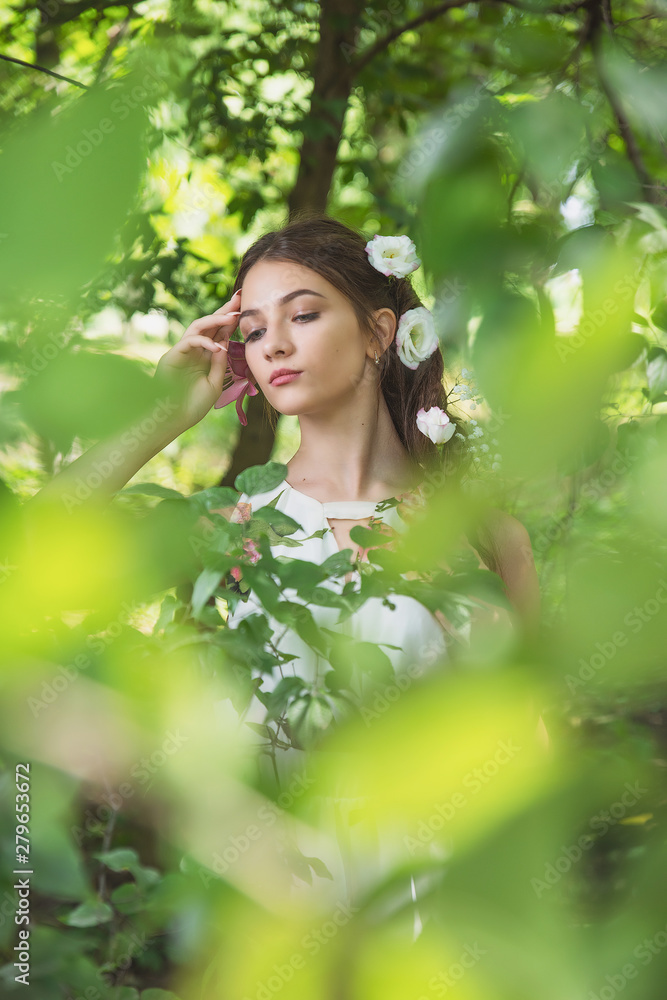 beautiful girl with lilies in her hair, flowers in the luxurious dark hair of a young lady beautiful girl with lilies in her hair, flowers in the luxurious dark hair of a young lady