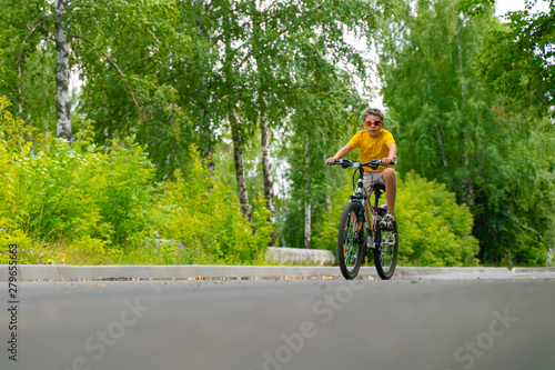 Teenager rides through the park on a bicycle