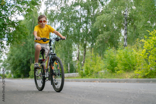 Teenager rides through the park on a bicycle