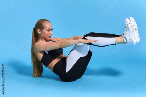 sweaty blonde hardworking sportswoman trying to keep balance. fulllength side view photo.