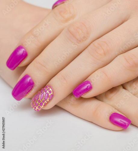 Manicure withpink nail Polish on women's hand.
