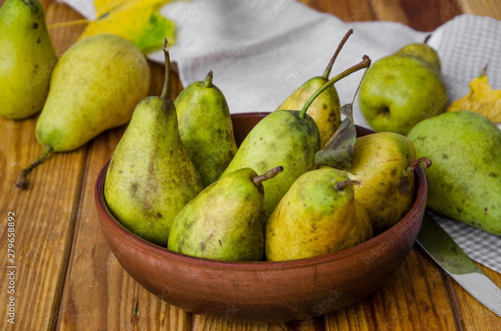 fresh ripe pears in a clay bowl on a dark wooden background. Rustic style fresh ripe pears in a clay bowl on a dark wooden background. Rustic style