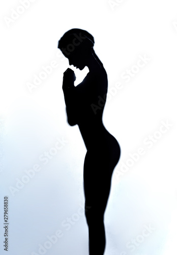 young sexy girl holding hands together looking down, wishing happiness health to family, sincere dream, close up side view photo. sport concept . meditation