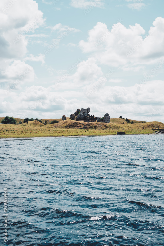 castle ruin next to river in ireland