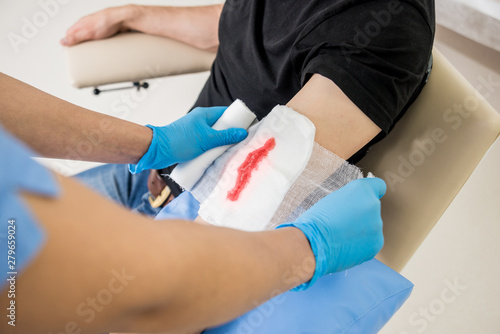 Quadro su tela Nurse dressing wound for patient's hand with deep skin cutting.