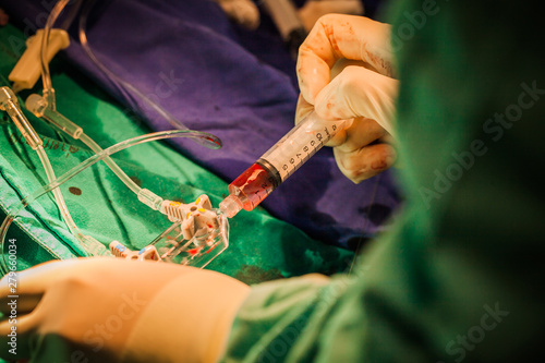 Cardiologist help to Patient in cardio catheterization room photo