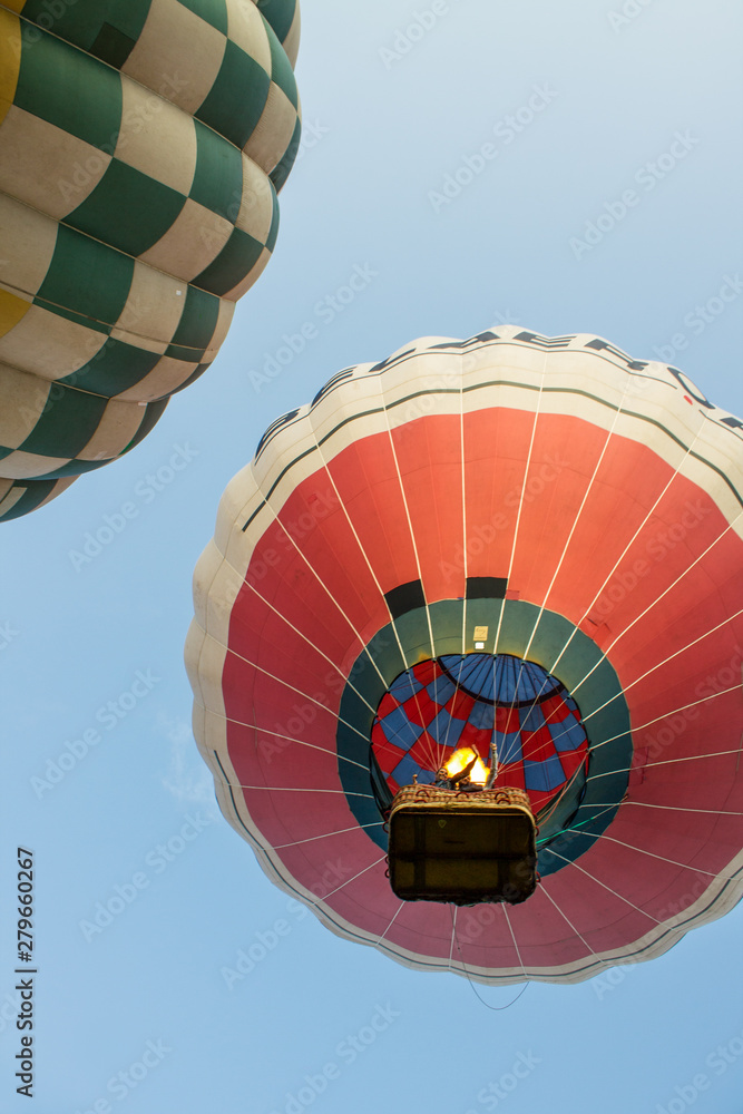 Obraz premium flying balloon with passengers in a basket against the blue sky at the festival of Aeronautics in Pereslavl-Zalessky Russia summer evening