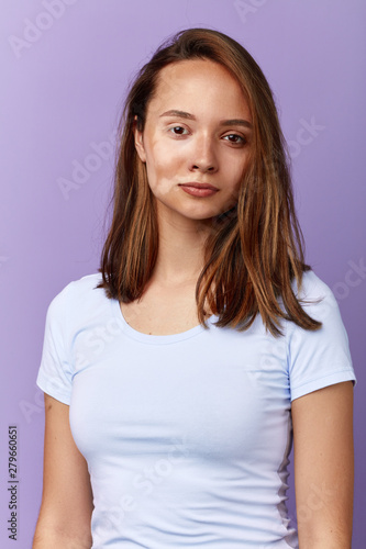 slim nice young woman has disturbance of skin color. close up portrait. isolated blue background, studio shot.