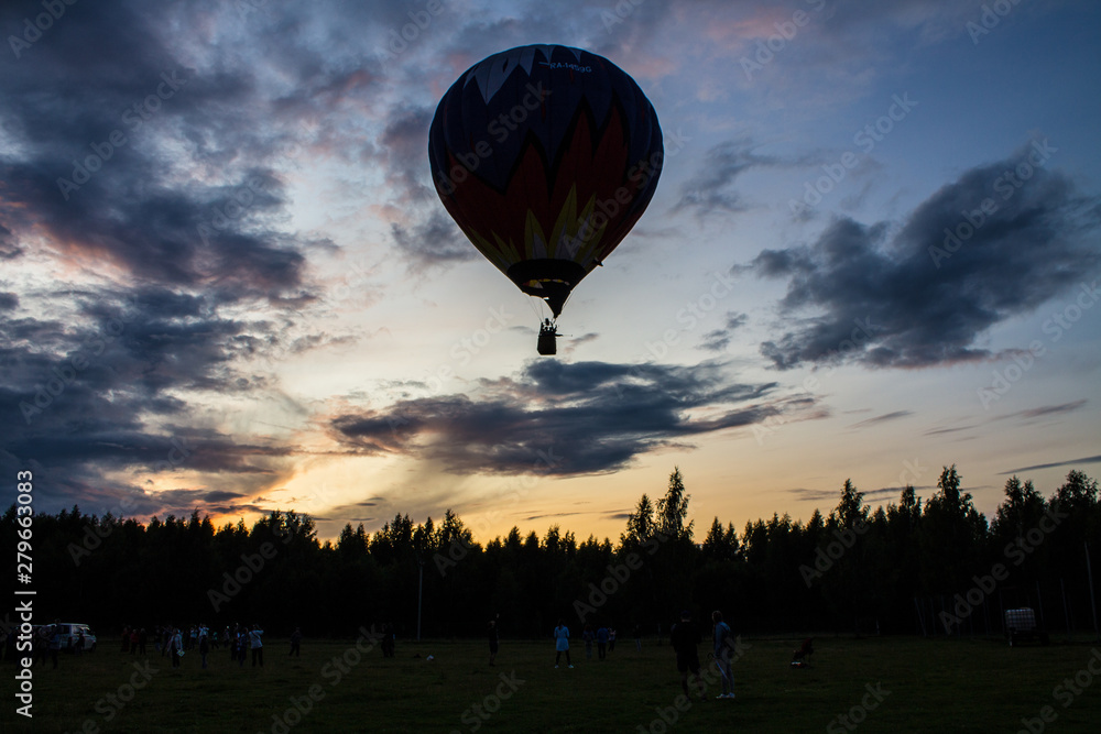 Obraz premium flying balloon with passengers in a basket against the blue sky at the festival of Aeronautics in Pereslavl-Zalessky Russia summer evening