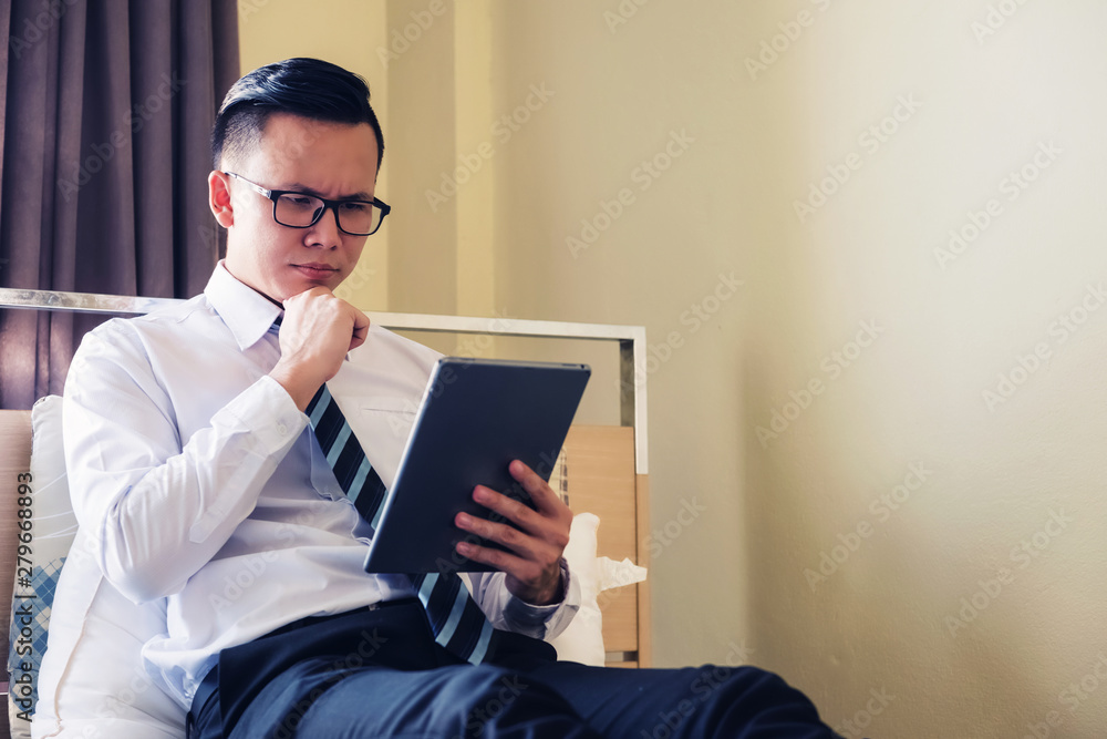 Businessman check tablet on hotel bed Businessman check tablet on hotel bed