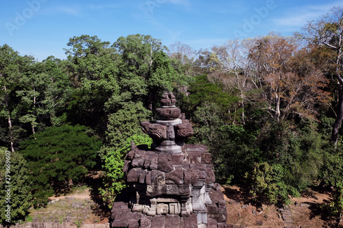 Ancient stone tower in the forest. The object of architectural art of medieval Southeast Asia. Stone carving, executed in Asian style.
