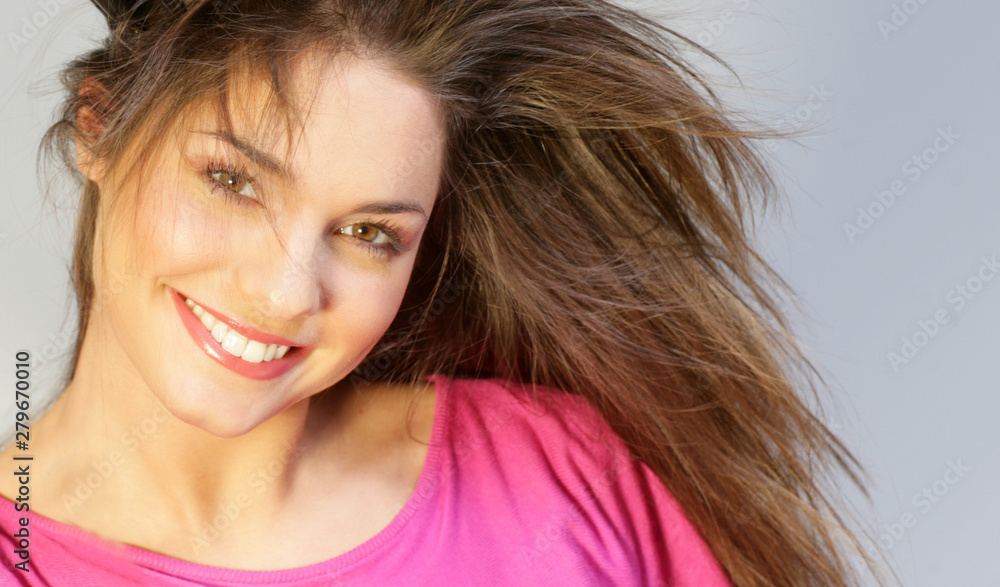 Fototapeta premium Jeune femme brune souriante avec un top rose