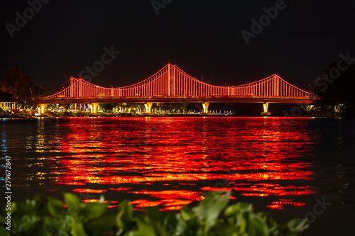 The city lights of Surat Thani at twilight with the Bridge and reflection over the Tapee River in Surat Thani , Thailand photo