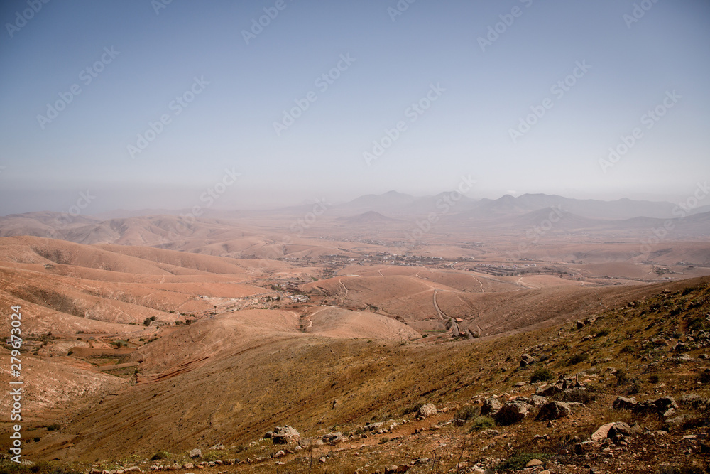 Typical landscape with red volcanic mountains and a small village close to betancuria on the Canary Island Fuerteventura, Spain.