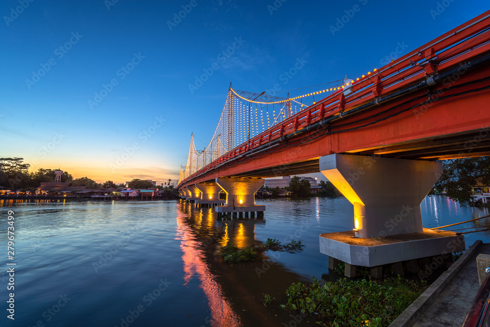 Obraz premium The city lights of Surat Thani at twilight with the Bridge and reflection over the Tapee River in Surat Thani , Thailand