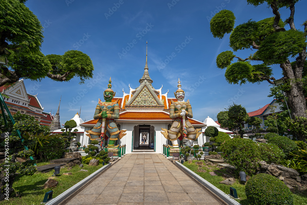 Bangkok, Thailand at Wat Arun Temple, Giant Statue guarding the entrance to the temple, Bangkok, Thailand. on the Thonburi west bank of the Chao Phraya River. Bangkok, Thailand at Wat Arun Temple, Giant Statue guarding the entrance to the temple, Bangkok, Thailand. on the Thonburi west bank of the Chao Phraya River.