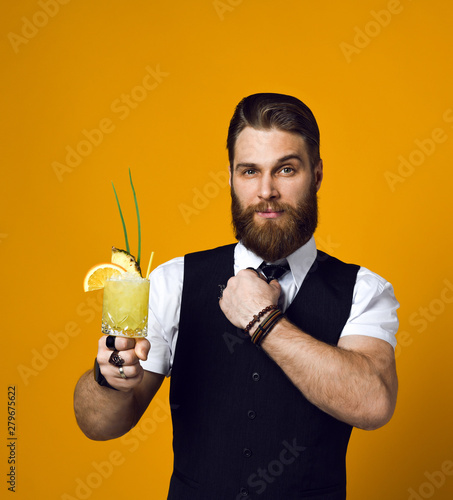 bearded barman with beard holding cocktail in waistcoat photo
