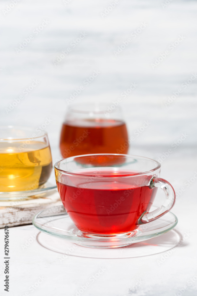 assortment of tea in glass cups on white background, vertical closeup assortment of tea in glass cups on white background, vertical closeup