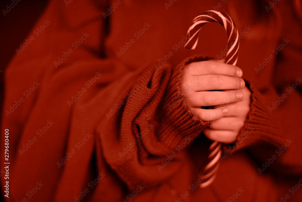 Child and candy cane, girl holding new year candy Child and candy cane, girl holding new year candy