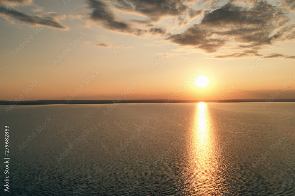 Fototapeta premium Beautiful view of the sea and sunset. Aerial view from flying drone of a beautiful nature landscape with dramatic clouds sunset sky and views of the sea surface. Postcard view. Nature