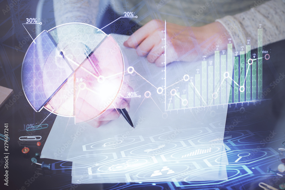 Hand taking notes in notepad. Forex chart holograms in front. Concept of research. Multi exposure Hand taking notes in notepad. Forex chart holograms in front. Concept of research. Multi exposure