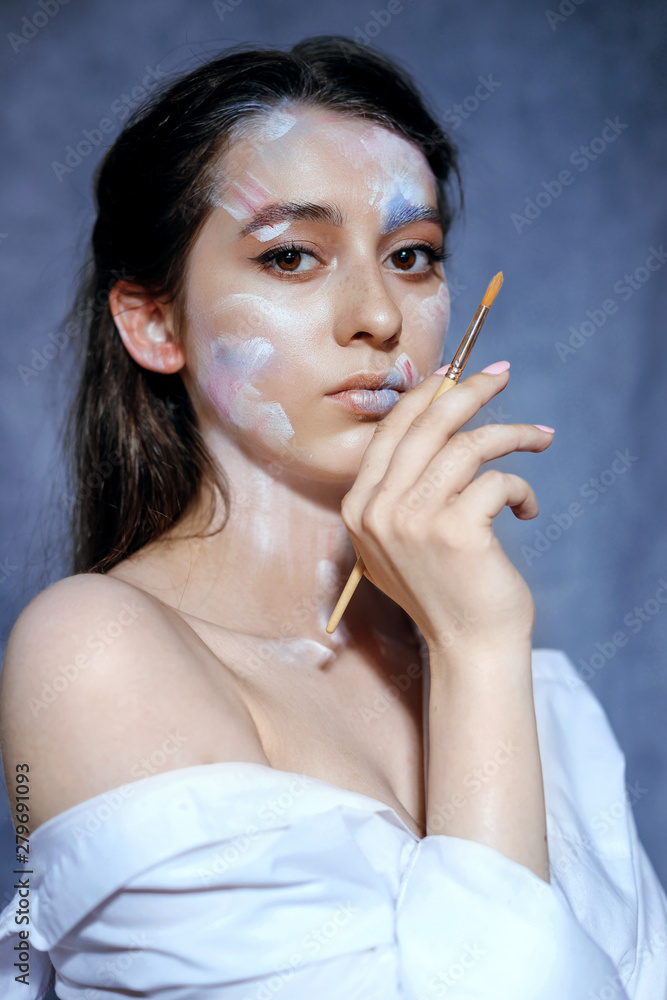 Obraz premium Creative fashion beauty portrait of a beautiful young woman with an artistic tassel in her hands.