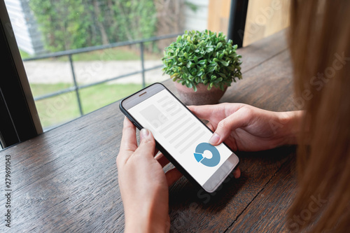 Woman used mobile phone in the desk with mock up on screen, business technology concept photo