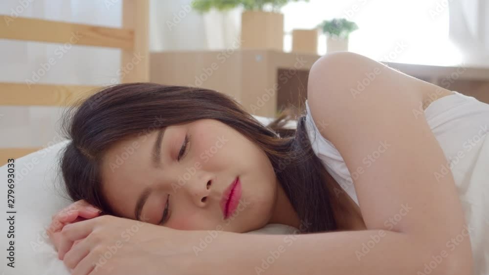 Slow motion - Beautiful attractive young Asian woman wake up, smiling and stretching her arms in her bed in bedroom. Young asia female use relax time at home. Lifestyle women relax at home concept. Slow motion - Beautiful attractive young Asian woman wake up, smiling and stretching her arms in her bed in bedroom. Young asia female use relax time at home. Lifestyle women relax at home concept.