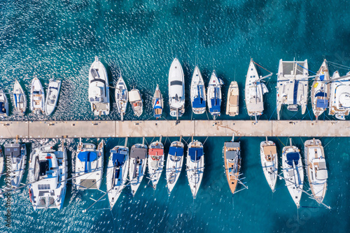 Luftaufnahme einer Marina mit zahlreichen Segelbooten und Yachten über türkisblauem Meer photo