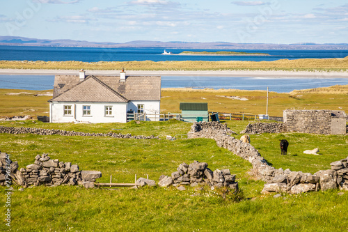 Obraz na plátne Farm house and field with stone walls and beach, Galway bay in background