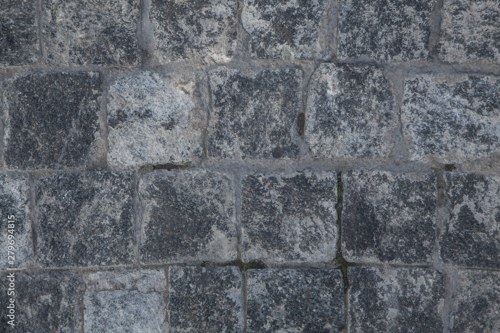 Fototapeta premium Abstract background of gray cobblestone pavement,close-up, top view.