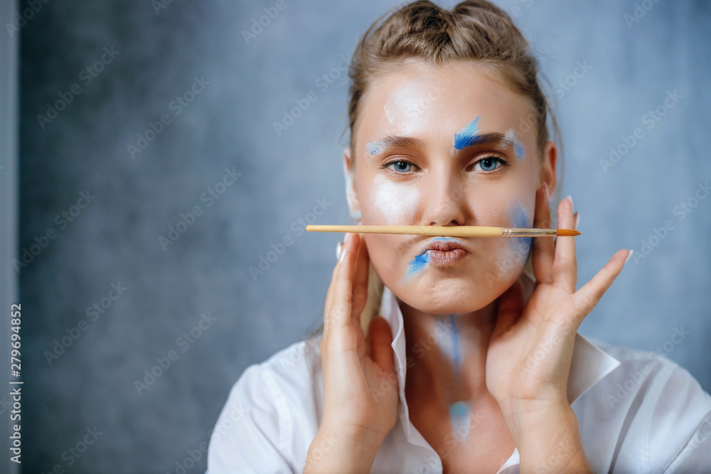 Fototapeta premium Creative fashion beauty portrait of a beautiful young blonde woman with an artistic tassel in her hands.