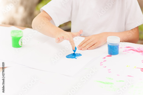 the child draws with finger paints