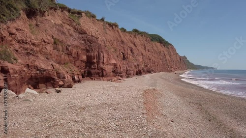 Pan from the red cliffs to the sea at the start of the Jurassic Coast World Heritage Site in Sidmouth in Devon England.